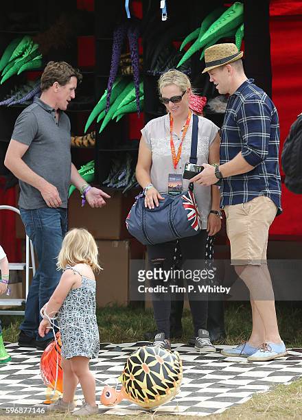 Jockey AP McCoy with Zara Tindall and Mike Tindall after buying their daughter Mia Tindall a toy balloon during day three of The Big Feastival at...