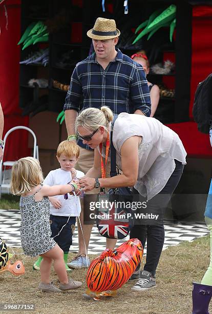 Zara Tindall and Mike Tindall buy their daughter Mia Tindall a toy balloon during day three of The Big Feastival at Alex James' Farm on August 28,...