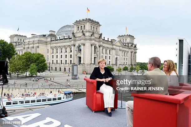 German Chancellor Angela Merkel talks with tv-journalists Tina Hassel and Thomas Baumann during her summer interview with German public tv chain ARD...