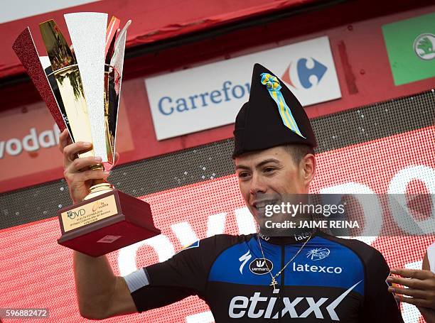 Etixx-Quick Step's Spanish cyclist David de la Cruz poses with his trophy as he celebrates on the podium after winning the 9th stage of the 71st...