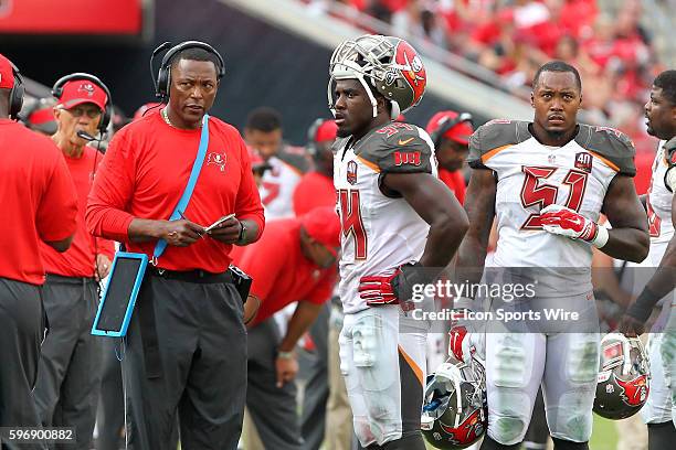 Linebacker coach Hardy Nickerson speaks with Lavonte David as linebacker Danny Lansanah looks on during the regular season game between the Tennessee...
