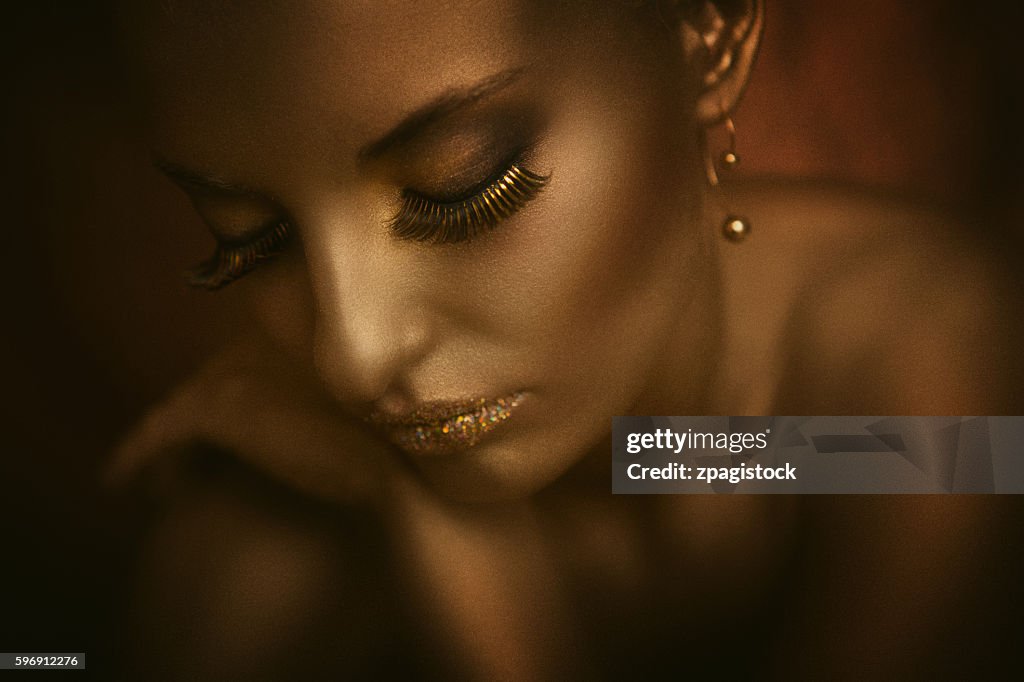 Portrait of a woman with golden body painting