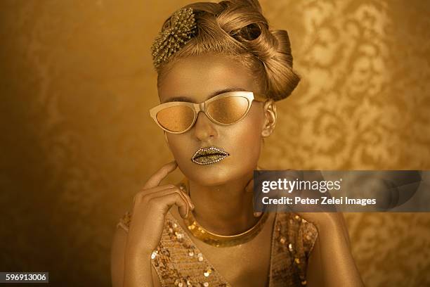 woman with golden body painting with golden eyeglasses - body paint stock pictures, royalty-free photos & images