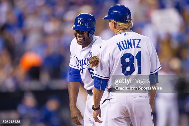 Kansas City Royals center fielder Lorenzo Cain laughs on first base with Kansas City Royals first base coach Rusty Kuntz during the MLB American...