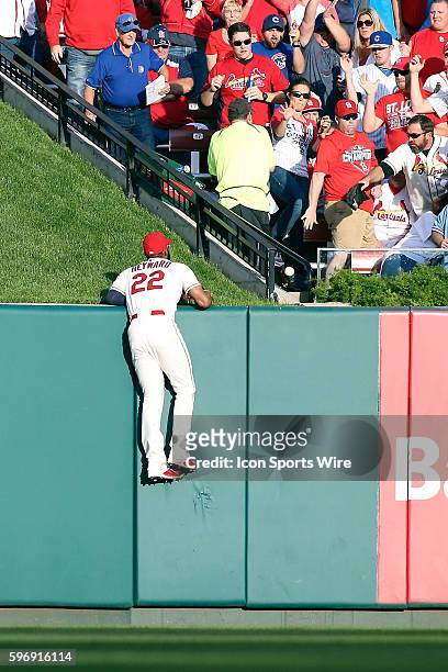 St. Louis Cardinals right fielder Jason Heyward hangs on to the wall as he watches a two run home run by Chicago Cubs right fielder Jorge Soler...