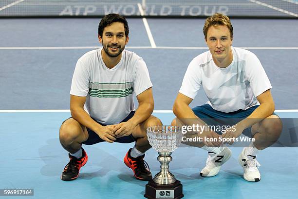 Henri Kontinen of Finland and Treat Huey of the Philippines pose for photograph with the winning trophy after their 7-6, 6-2 victory over top seeds...