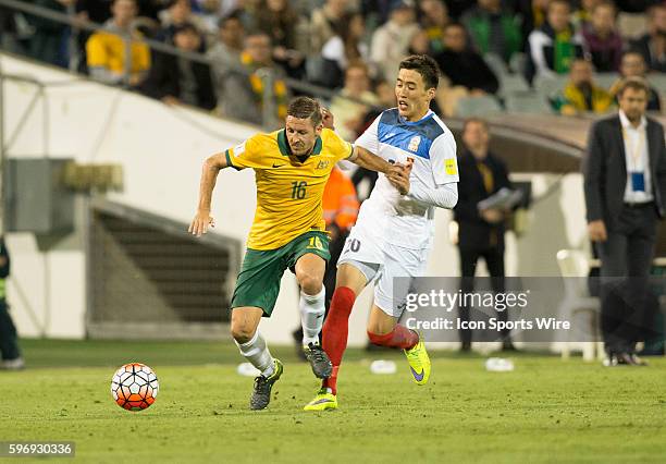 Nathan Burns of Australia of Australia attempts to run away from Duishebekov Bahtiyar of Kyrgyzstan in the Asia Group FIFA 2018 World Cup qualifying...