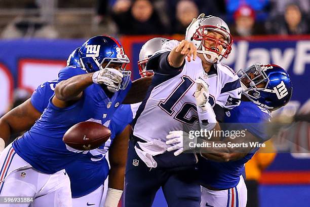 New England Patriots quarterback Tom Brady loses the football after he gets hit by New York Giants defensive end Robert Ayers and New York Giants...