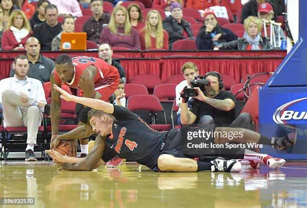 Fresno State Bulldogs guard Marvelle Harris and University of Pacific Tigers guard Aaron Hendricks struggle for the loose ball during the Fresno...