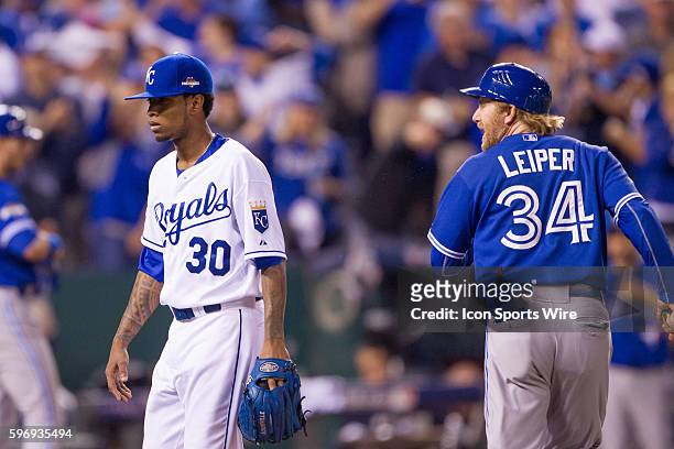 Toronto Blue Jays first base coach Tim Leiper says something to Kansas City Royals starting pitcher Yordano Ventura as he leaves the field after the...