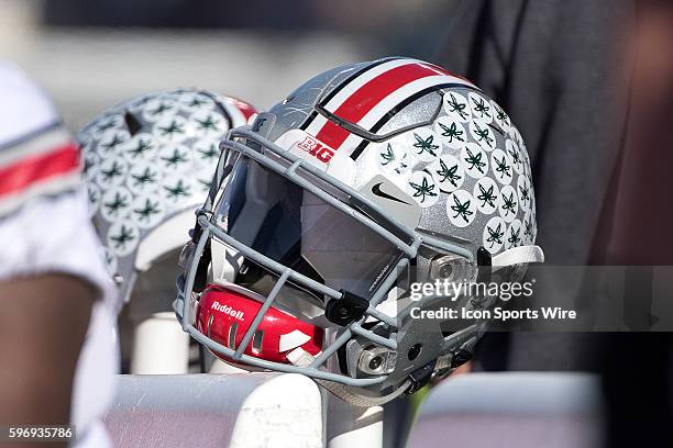 An Ohio State Buckeyes helmet rests on the bench in action during a Big Ten football game between the Illinois Fighting Illini and the Ohio State...