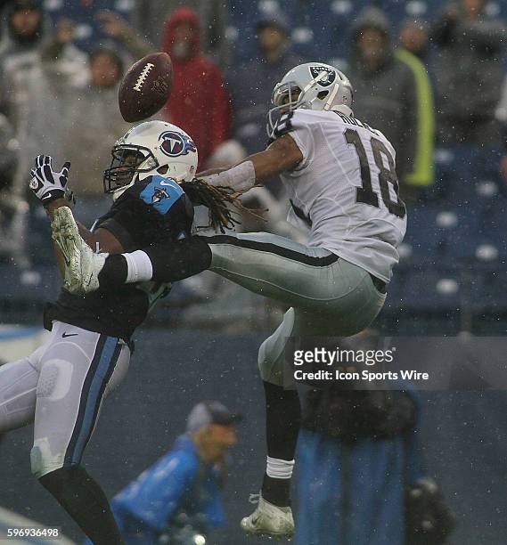 Tennessee Titans Safety Michael Griffin knocks the ball away from Oakland Raiders Wide Receiver Andre Holmes during the NFL football game between the...