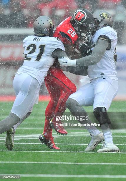 In the snow Utah Utes running back Joe Williams gets tacked by Colorado Buffaloes defensive back Jered Bell during a game between Colorado and Utah....