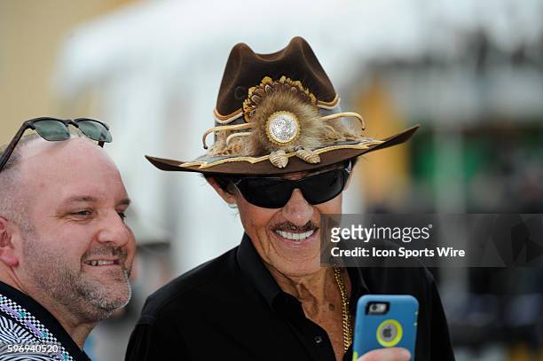 Richard Petty takes a selfie a fan in the garage during a practice session for the Ford EcoBoost 400 NASCAR race at the Homestead Miami Speedway in...