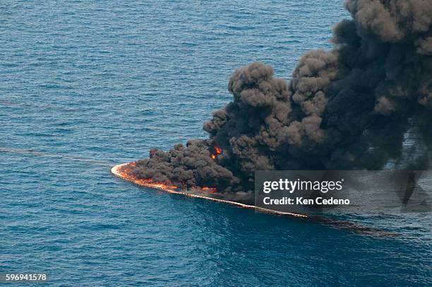 Smoke rises from a controlled burn of oil on the surface of the water near the site of the BP Deepwater Horizon oil spill in the Gulf of Mexico,...