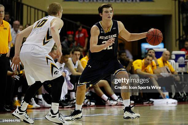 Notre Dame Fighting Irish guard Steve Vasturia is defended by Iowa Hawkeyes guard Mike Gesell as he brings the ball toward the Irish basket during...