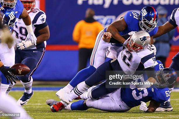 New England Patriots quarterback Tom Brady loses the football after he gets hit by New York Giants defensive end Robert Ayers and New York Giants...