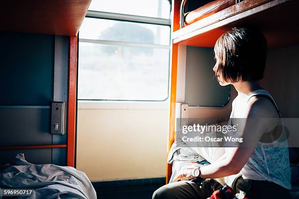 woman backpacker traveling on sleeper train - coche cama fotografías e imágenes de stock