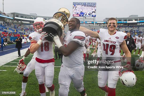 Louisville Cardinals tight end Cole Hikutini and offensive tackle Aaron Epps and cornerback Joe Bradford hold up the Governor's Cup after defeating...