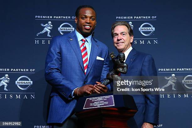 University of Alabama running back Derrick Henry and University of Alabama Head Coach Nick Saban pose with the Heisman Trophy at a press conference...