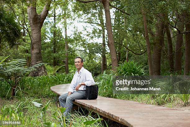 man sitting on walkway - lifestyle mann portrait stock pictures, royalty-free photos & images
