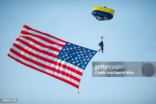 Navy skydiver parachutes into the stadium with the American flag trailing behind him before the NCAA football game between the Army Black Knights and...