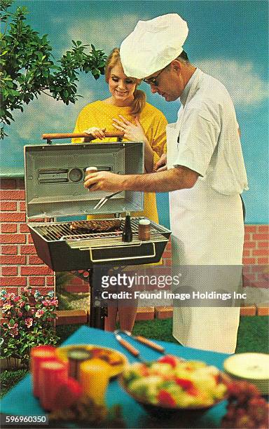 Vintage photograph of a man barbecuing while a woman watches in the 1960s.