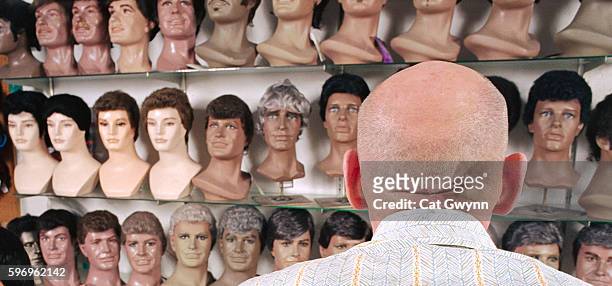 bald man choosing wig from store - peruk bildbanksfoton och bilder