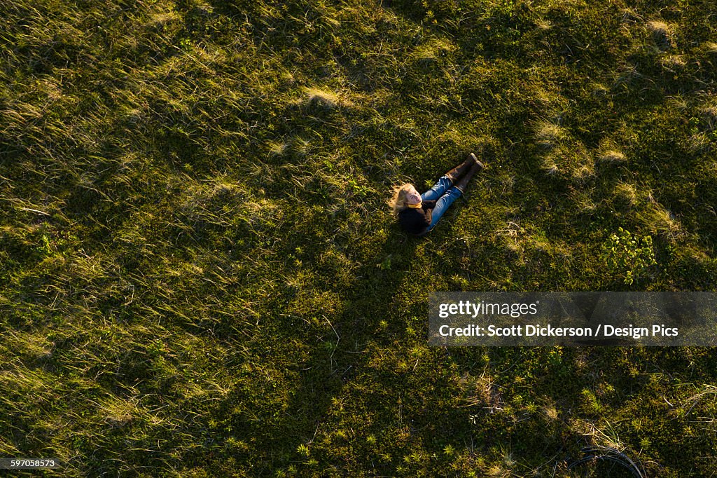 High Angle View Of A Girl Sitting In A Grass Field