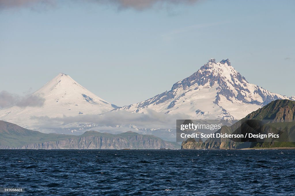 Shishaldin Volcano And Isanotski Peaks In The Background Of The Rugged Cliff Shoreline Of Cape Pankof On Unimak Island, Eastern Aleutian Islands