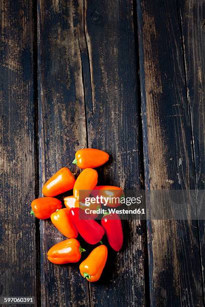 orange bell peppers on dark wood - orange bell pepper stockfoto's en -beelden