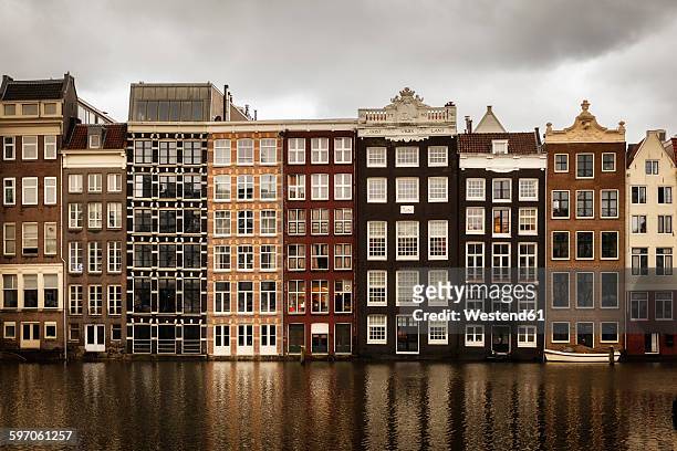 netherlands, amsterdam, row of houses at a gracht - amsterdam gracht stockfoto's en -beelden