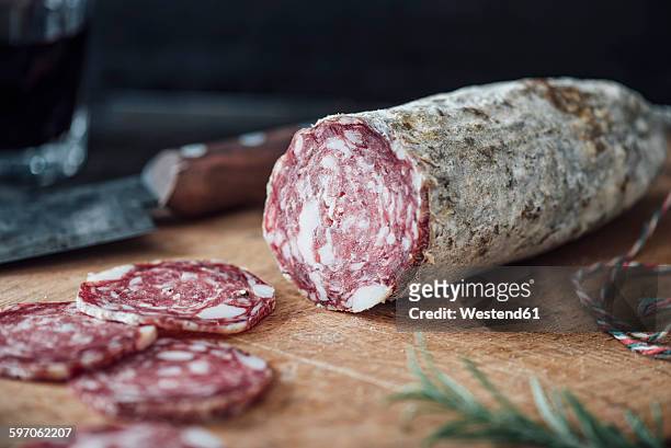 sliced salami on cutting board - salami stock-fotos und bilder