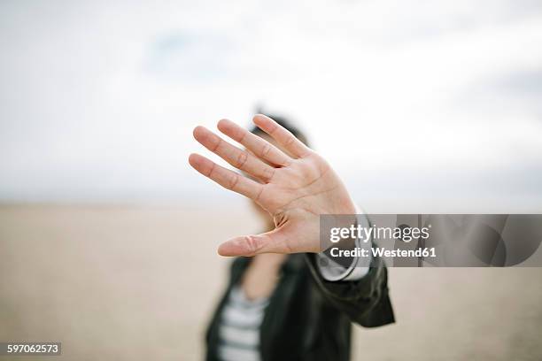 young woman hiding face behind her outstretched hand - 遮蔽的面孔 個照片及圖片檔