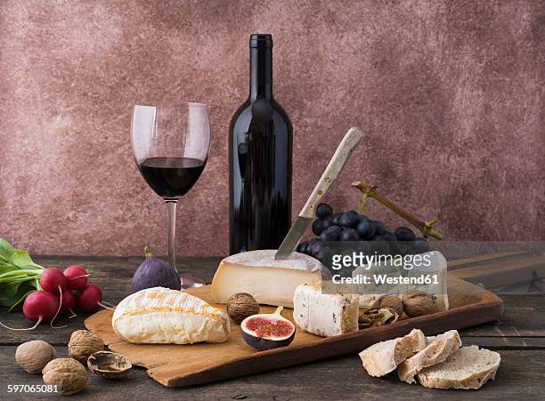 cheese platter with camembert, walnut cheese, gorgonzola, taleggio and red wine - cheese and wine bildbanksfoton och bilder
