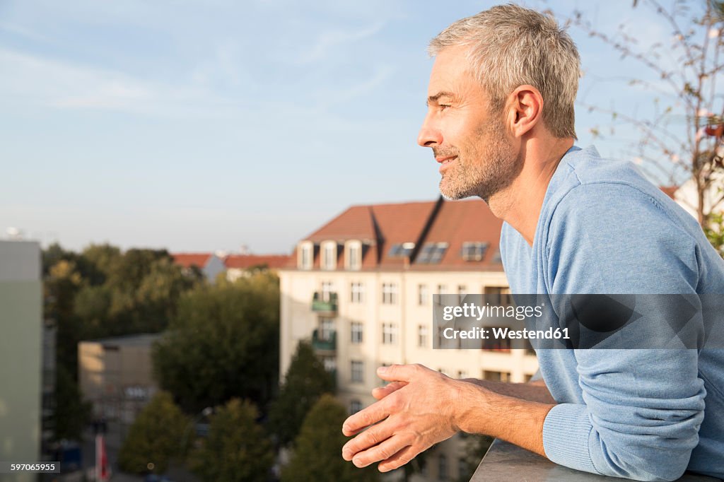 Mature man on balcony, enjoying the view