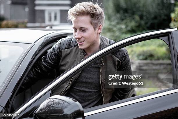 young man getting into car - entering car stock pictures, royalty-free photos & images