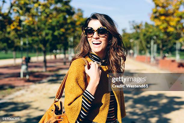 stylish woman at the park on a sunny autumn day - sunglasses woman stock pictures, royalty-free photos & images