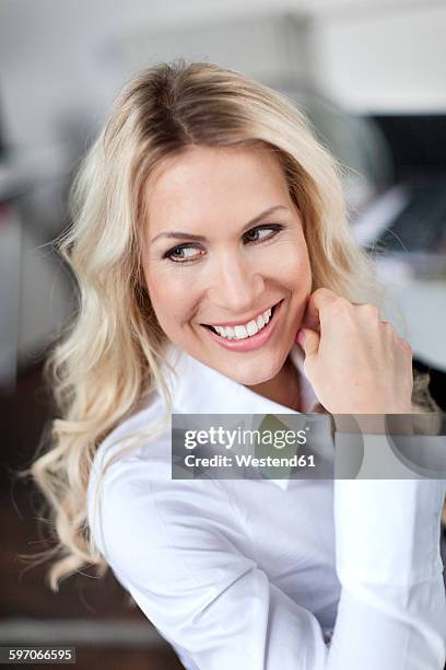 smiling blond woman in office - white blouse stock-fotos und bilder