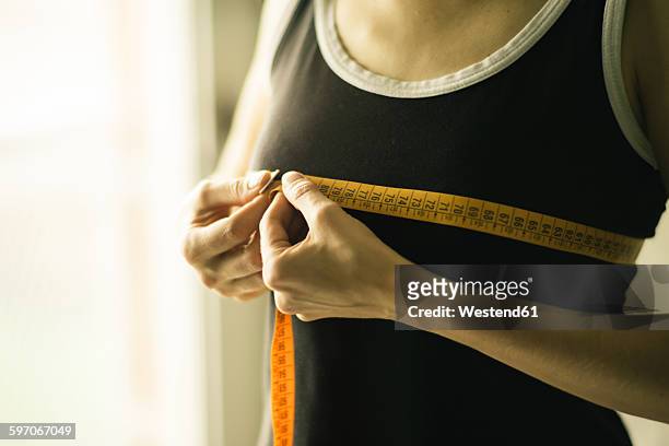 mid-adult woman measuring chest - chest or bust stock-fotos und bilder