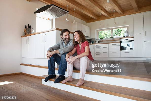 mature couple sitting on floor, talking about future - barefoot couples stock pictures, royalty-free photos & images