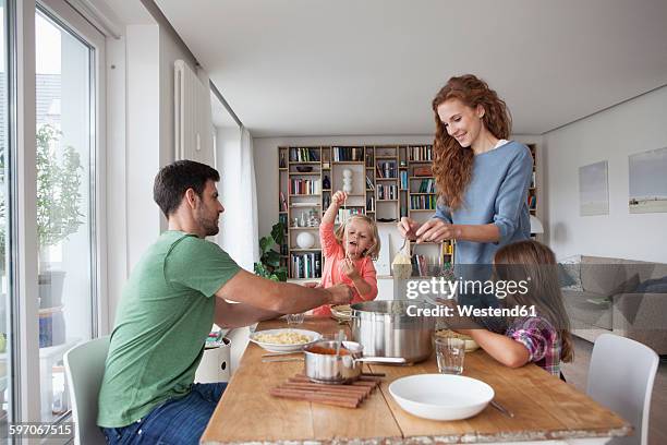 couple with two children going to have lunch together at home - mesa de jantar - fotografias e filmes do acervo