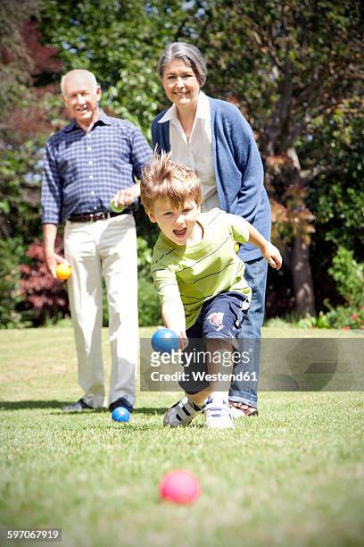 little boy playing boccia with his grandparents - boules stock-fotos und bilder