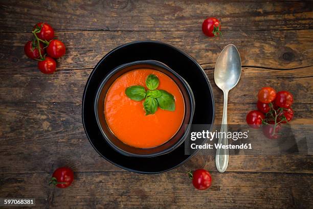 bowl of tomato cream soup garnished with basil leaves on wood - tomato soup 個照片及圖片檔