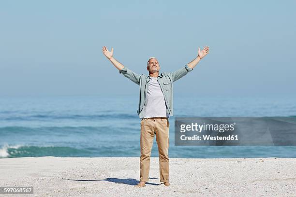 best ager at the beach - arms raised stock pictures, royalty-free photos & images