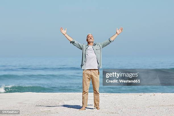 best ager at the beach - braços no ar imagens e fotografias de stock