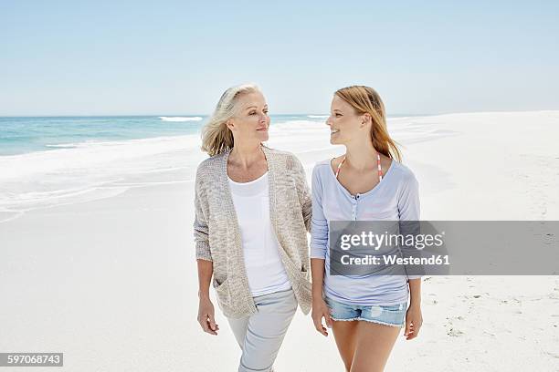 best ager with adult daughter at the beach - best ager woman stockfoto's en -beelden