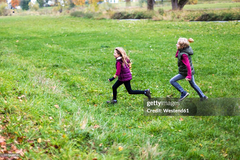 Boy and girl running over a meadow