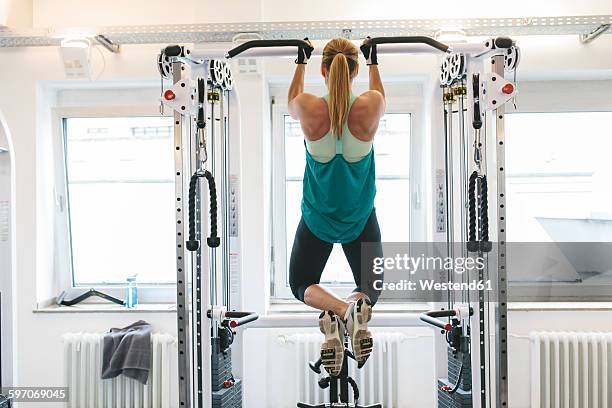 woman doing pull-ups in gym - chin ups stock pictures, royalty-free photos & images