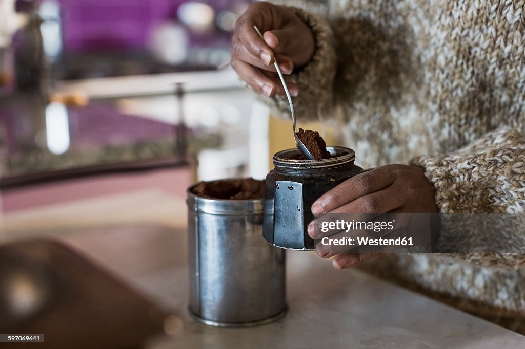 Young woman in kitchen preparing coffee